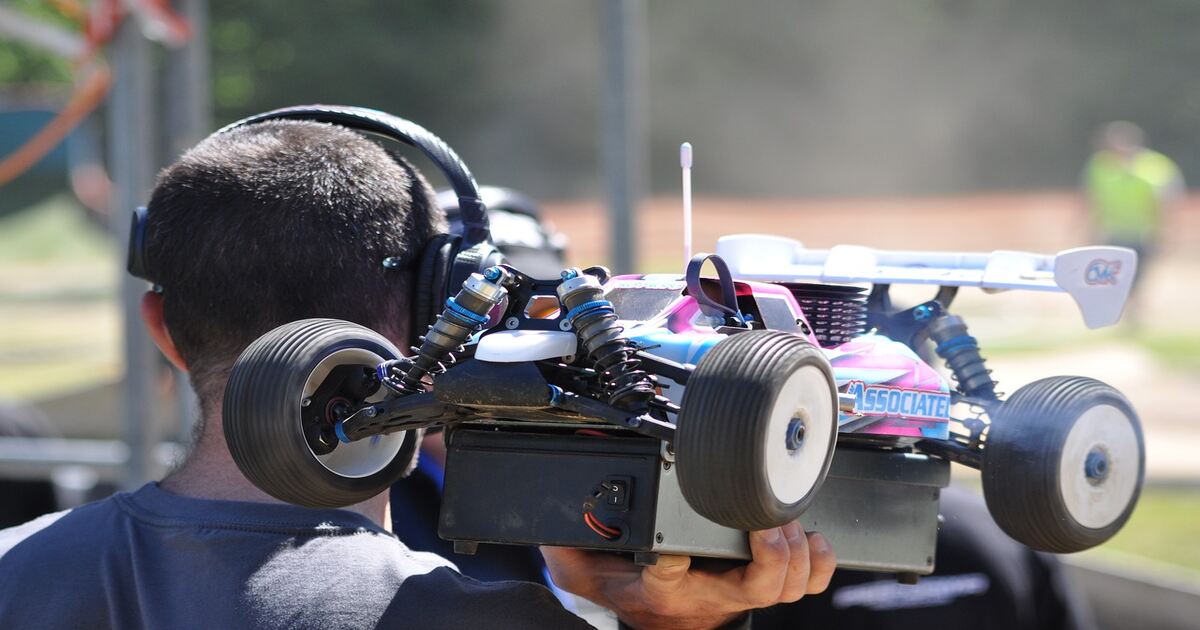 A person holding a large-sized RC buggy.
