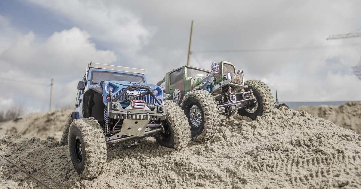 Two RC jeeps parked on a small hill.